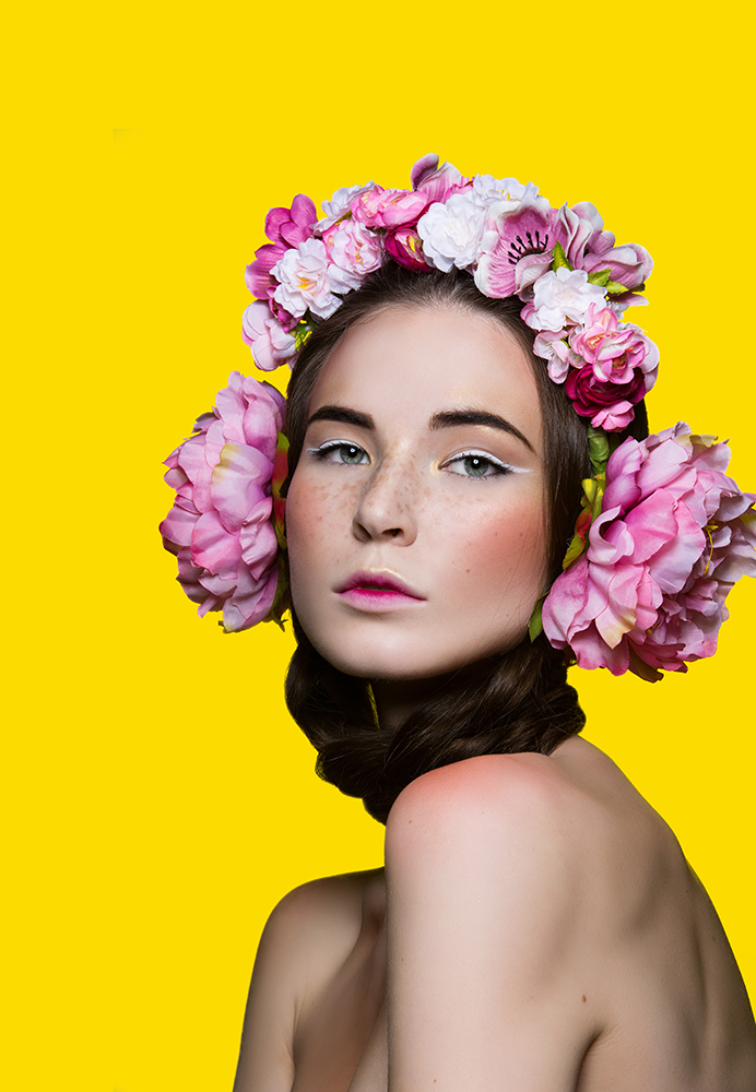 Girl whis flowers in hair on yellow background